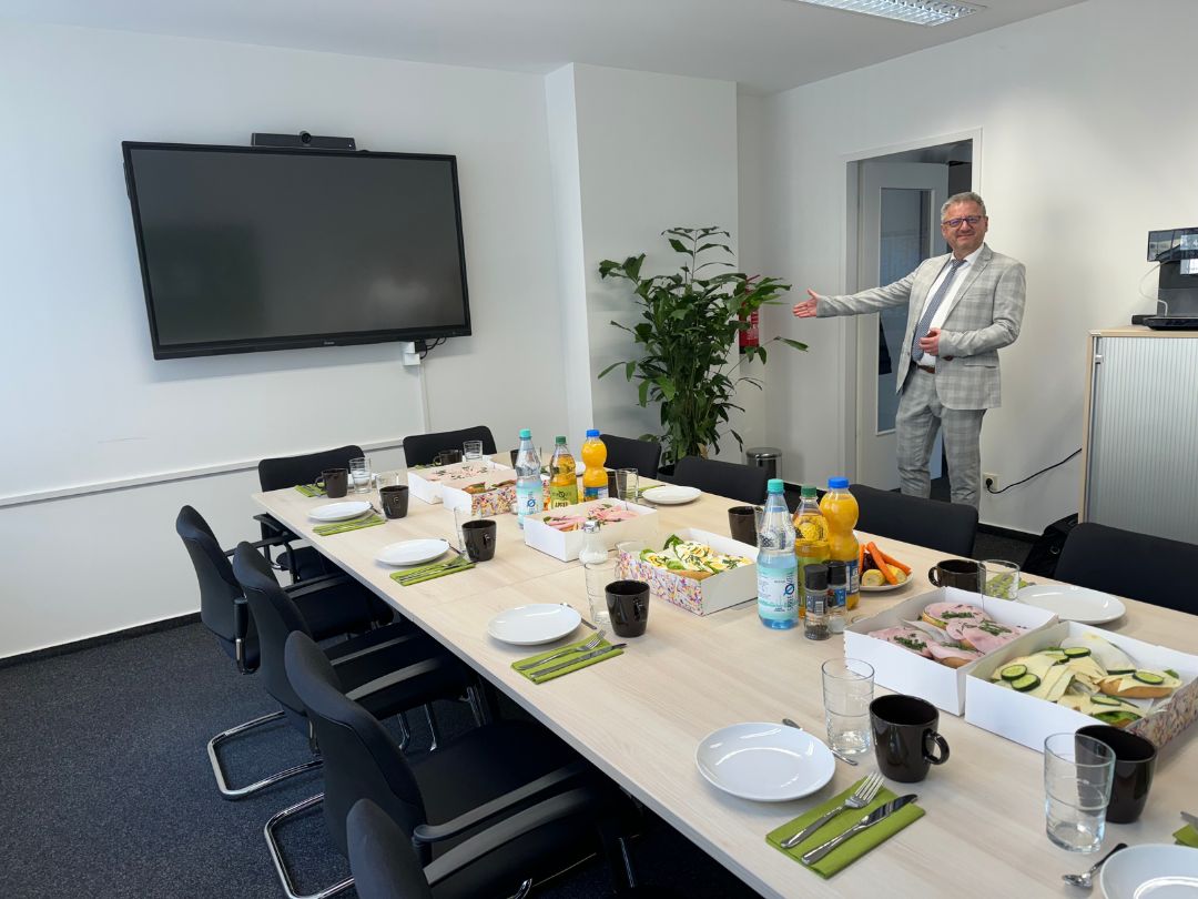 Büroleiter zeigt neues Besprechungszimmer